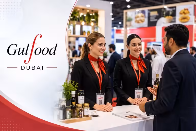 Event staffing agency for Gulfood Dubai assisting visitors at an exhibition booth.